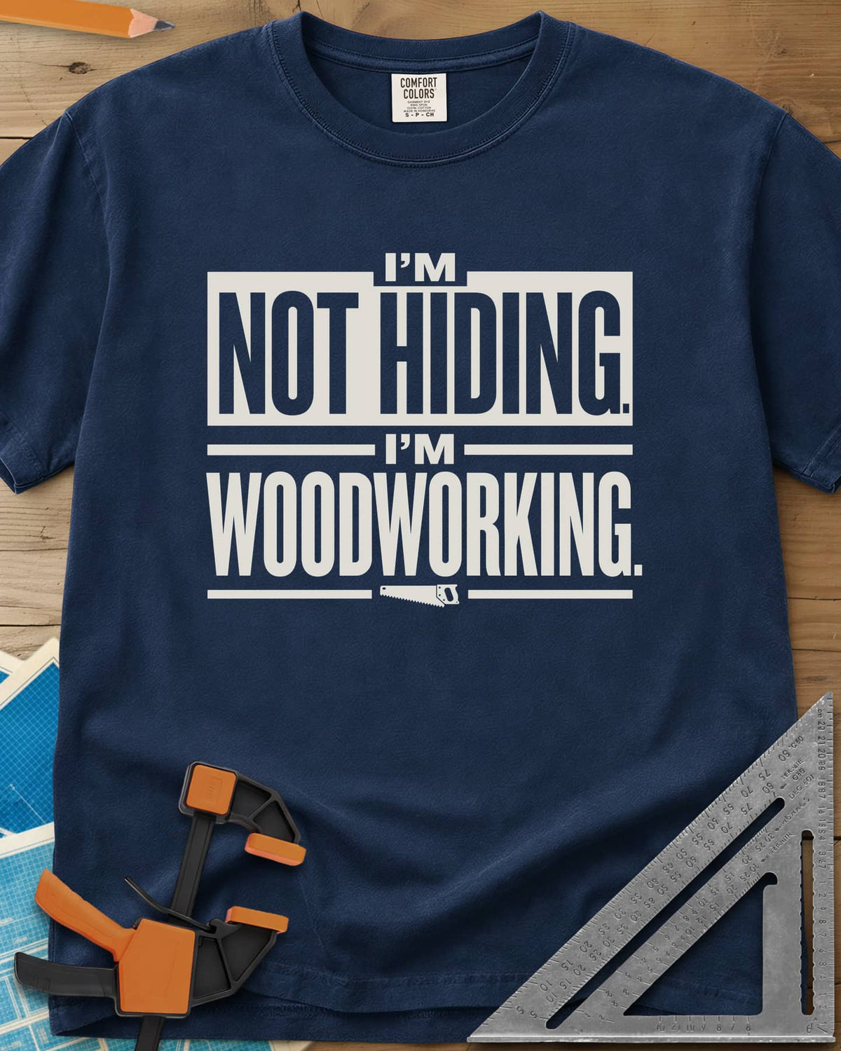 I'm Not Hiding I'm Woodworking heavyweight tee in Navy, block lettering with a knocked-out box and a small handsaw