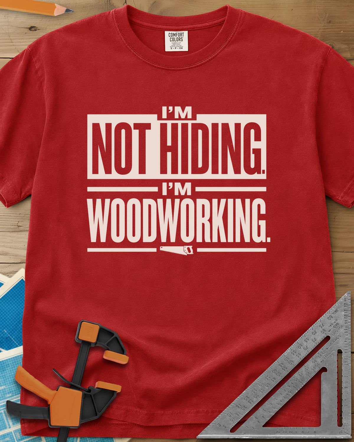 I'm Not Hiding I'm Woodworking heavyweight tee in Red, block lettering with a knocked-out box and a small handsaw