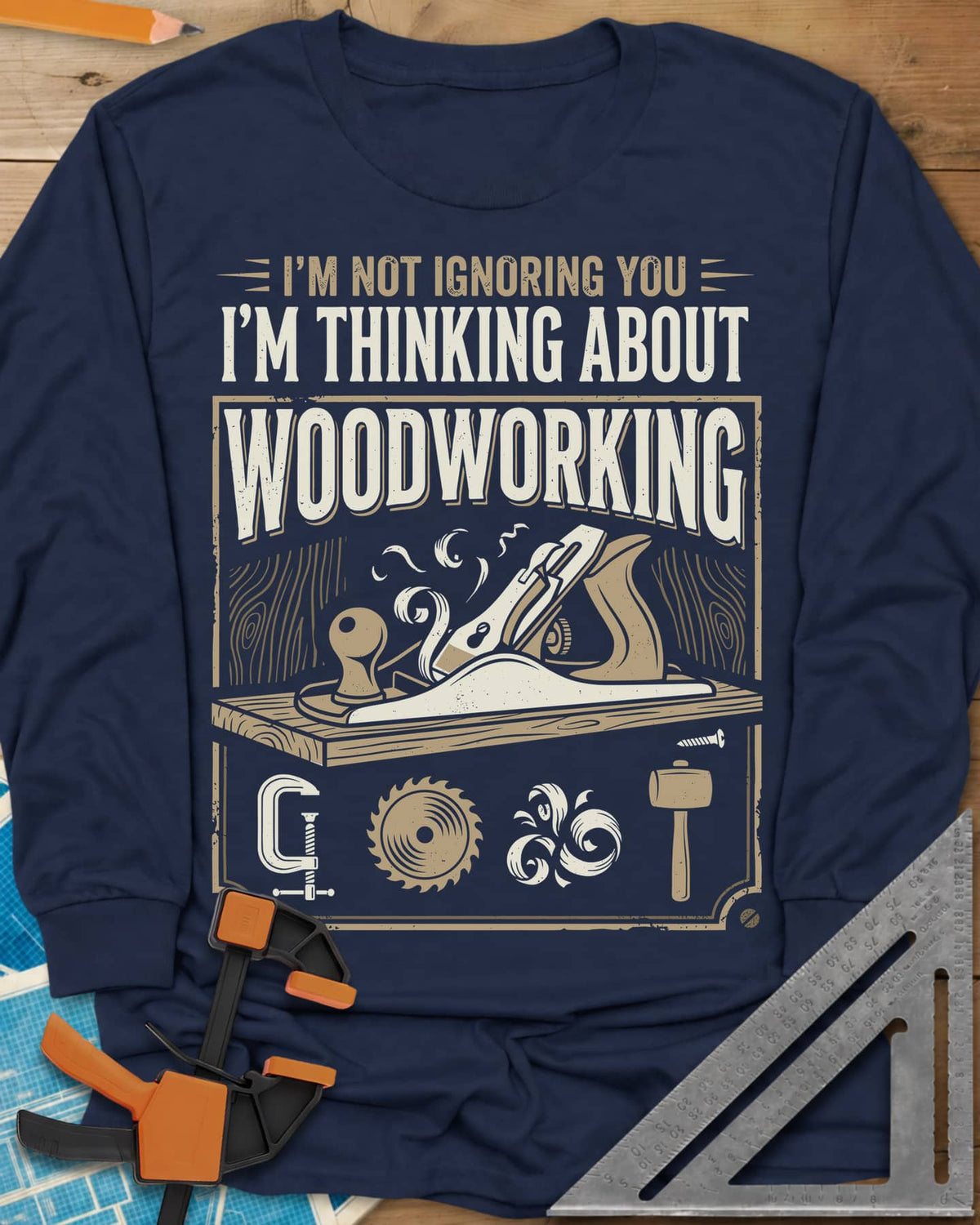 I'm Not Ignoring You I'm Thinking About Woodworking long sleeve shirt in Navy, a framed hand plane and shavings above clamp