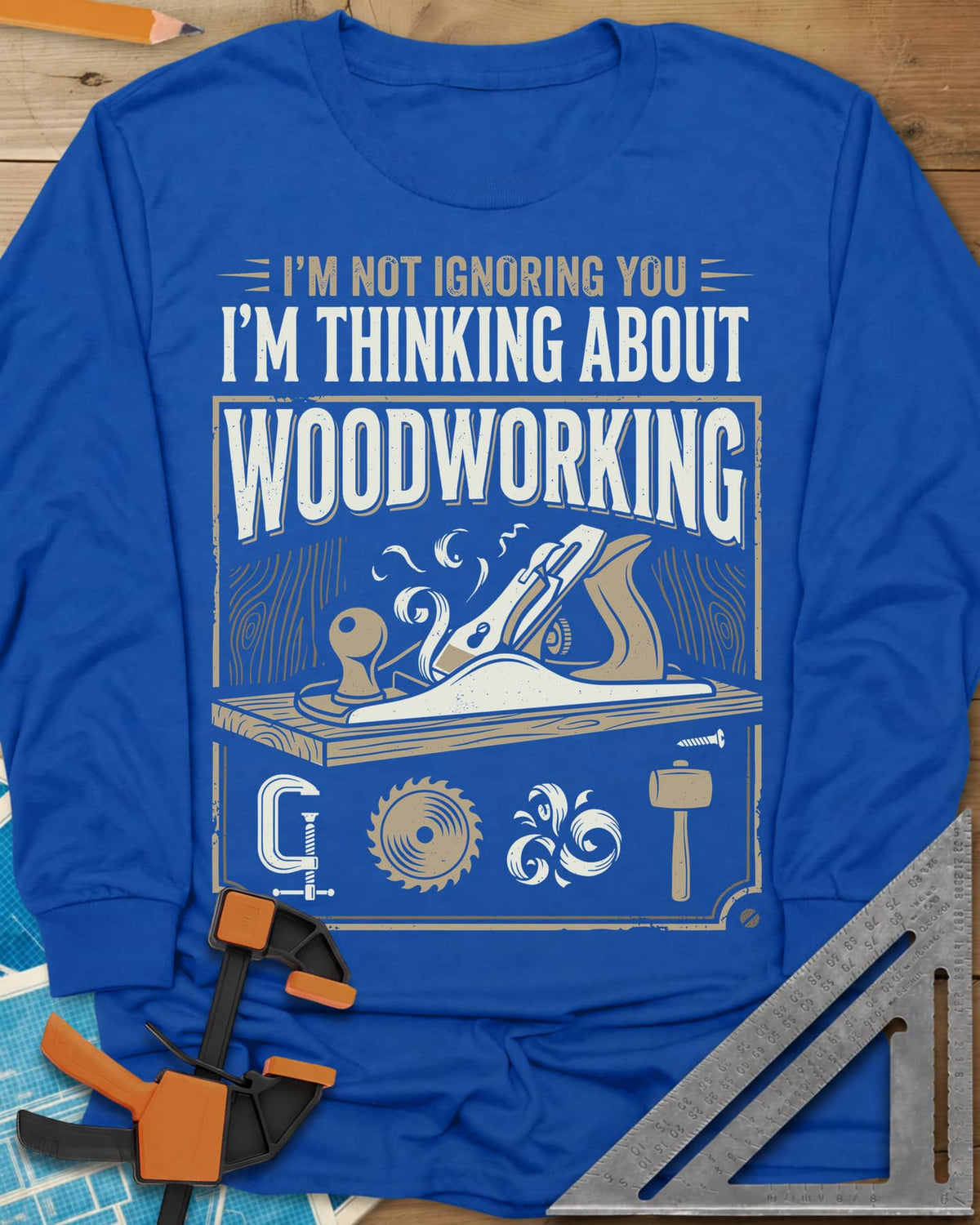 I'm Not Ignoring You I'm Thinking About Woodworking long sleeve shirt in Royal, a framed hand plane and shavings above
