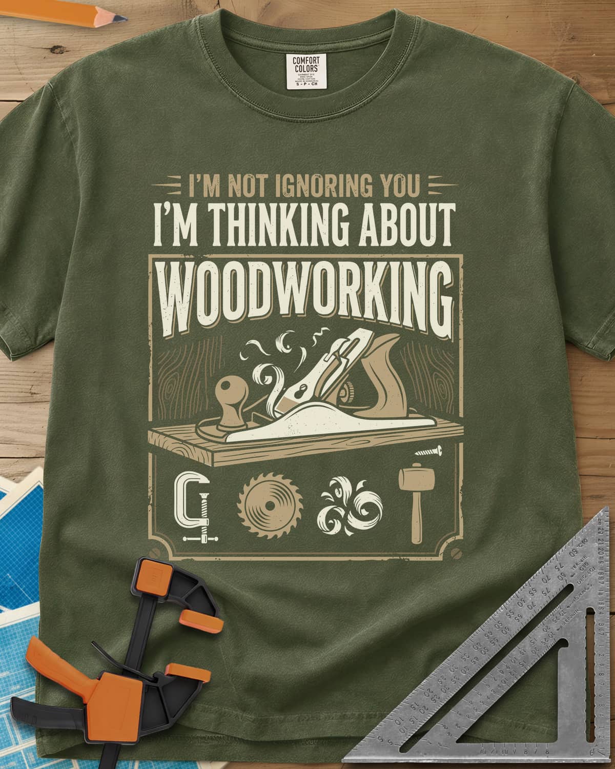 I'm Not Ignoring You I'm Thinking About Woodworking heavyweight tee in Hemp, a framed hand plane and shavings above clamp