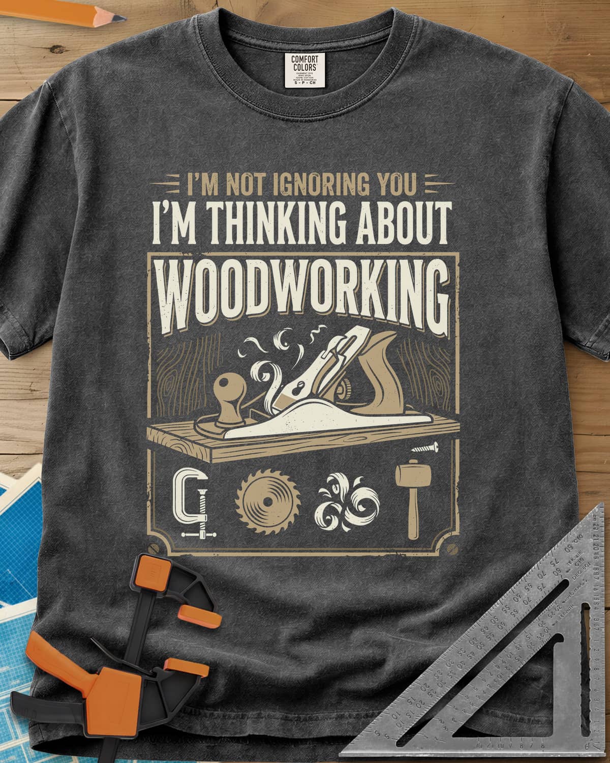 I'm Not Ignoring You I'm Thinking About Woodworking heavyweight tee in Pepper, a framed hand plane and shavings above clamp