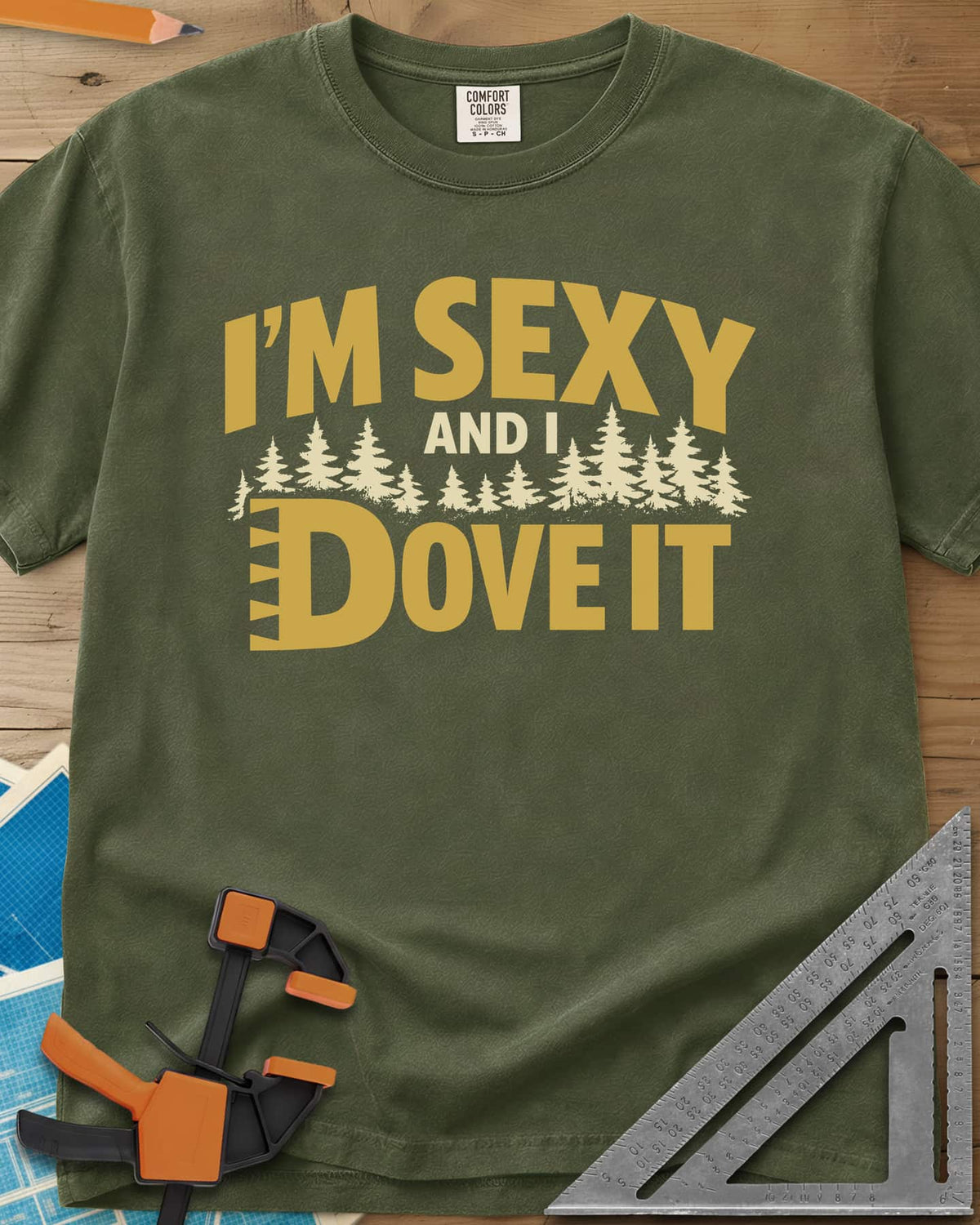 I'm Sexy and I Dove It heavyweight tee in Hemp, gold block lettering, a row of pine trees and a notched D
