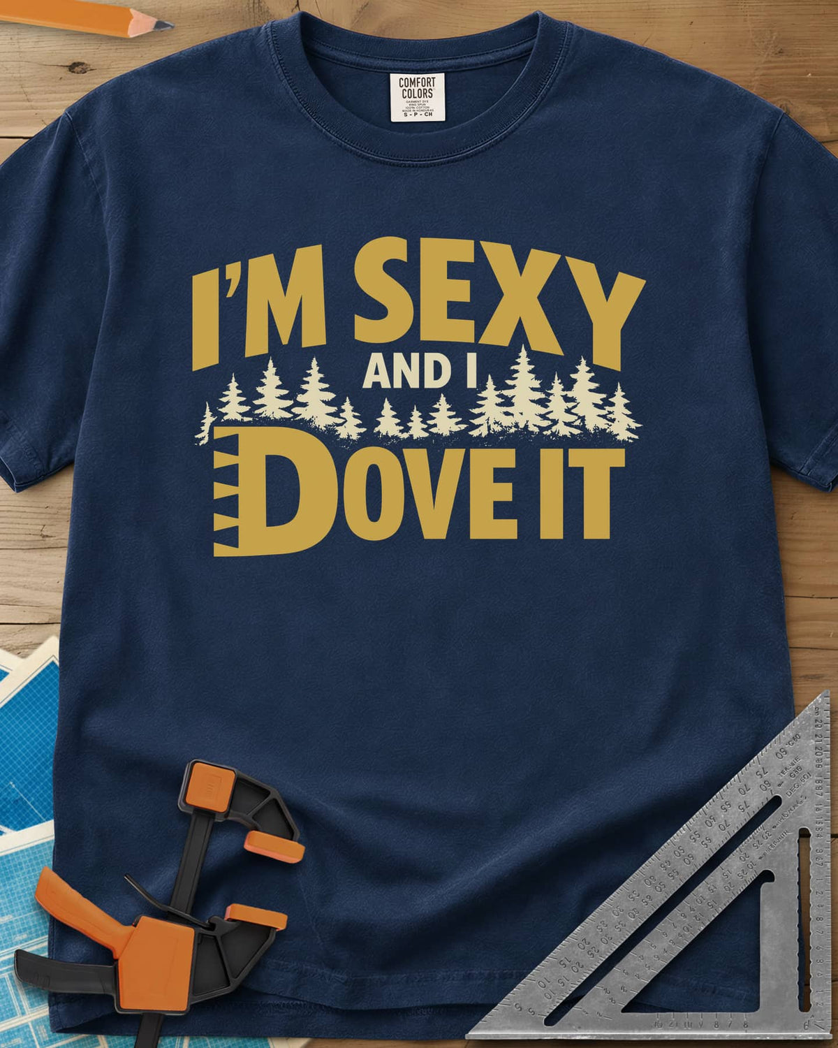I'm Sexy and I Dove It heavyweight tee in Navy, gold block lettering, a row of pine trees and a notched D