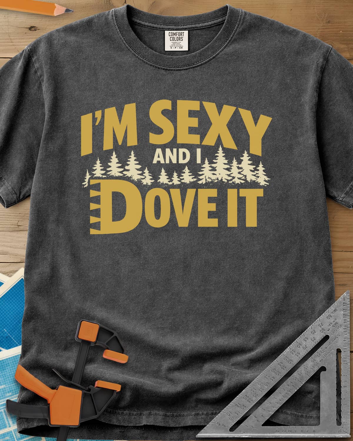 I'm Sexy and I Dove It heavyweight tee in Pepper, gold block lettering, a row of pine trees and a notched D
