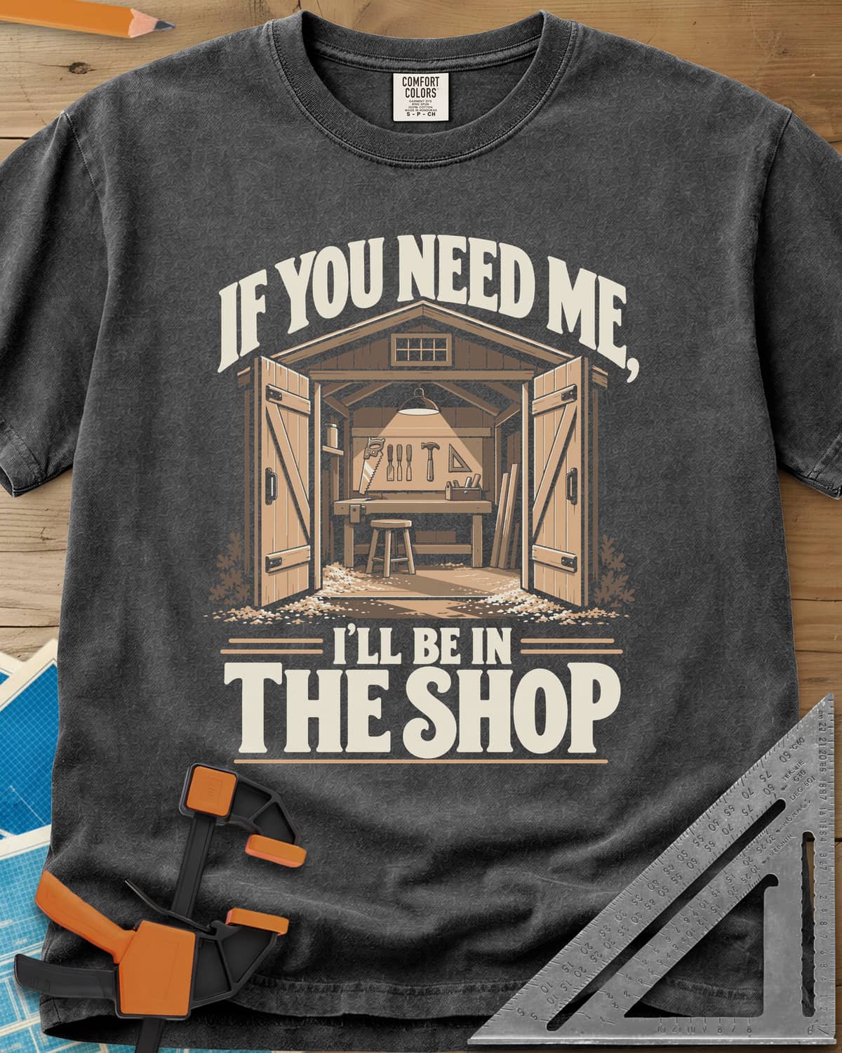 In The Shop heavyweight tee in Pepper, a small open workshop with a hanging lamp, bench and wall tools