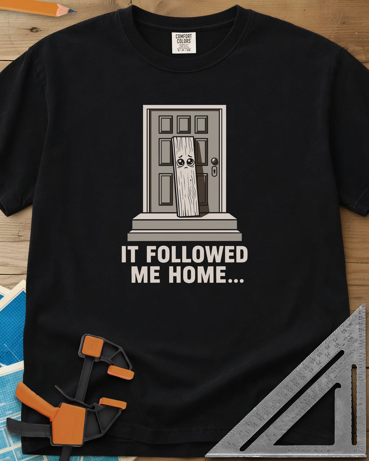 It Followed Me Home Woodworking heavyweight tee in Black, sad-eyed plank of wood waiting on a doorstep