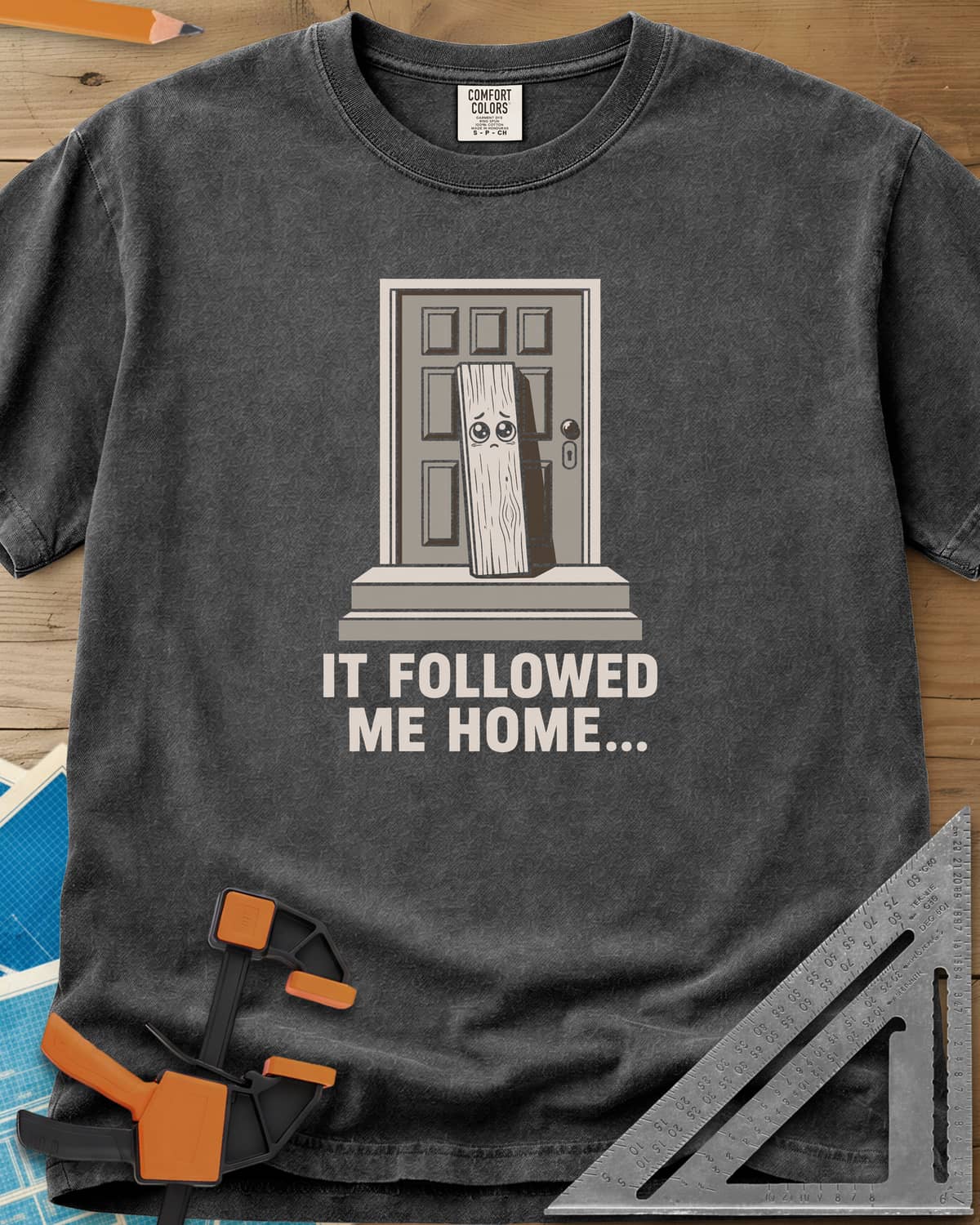 It Followed Me Home Woodworking heavyweight tee in Pepper, sad-eyed plank of wood waiting on a doorstep