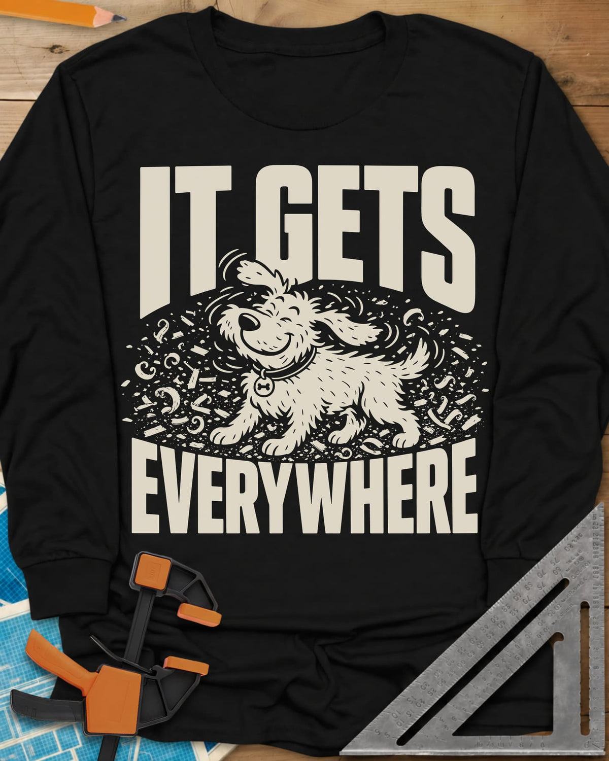 It Gets Everywhere long sleeve shirt in Black, a happy shaggy dog shaking in a swirl of wood shavings