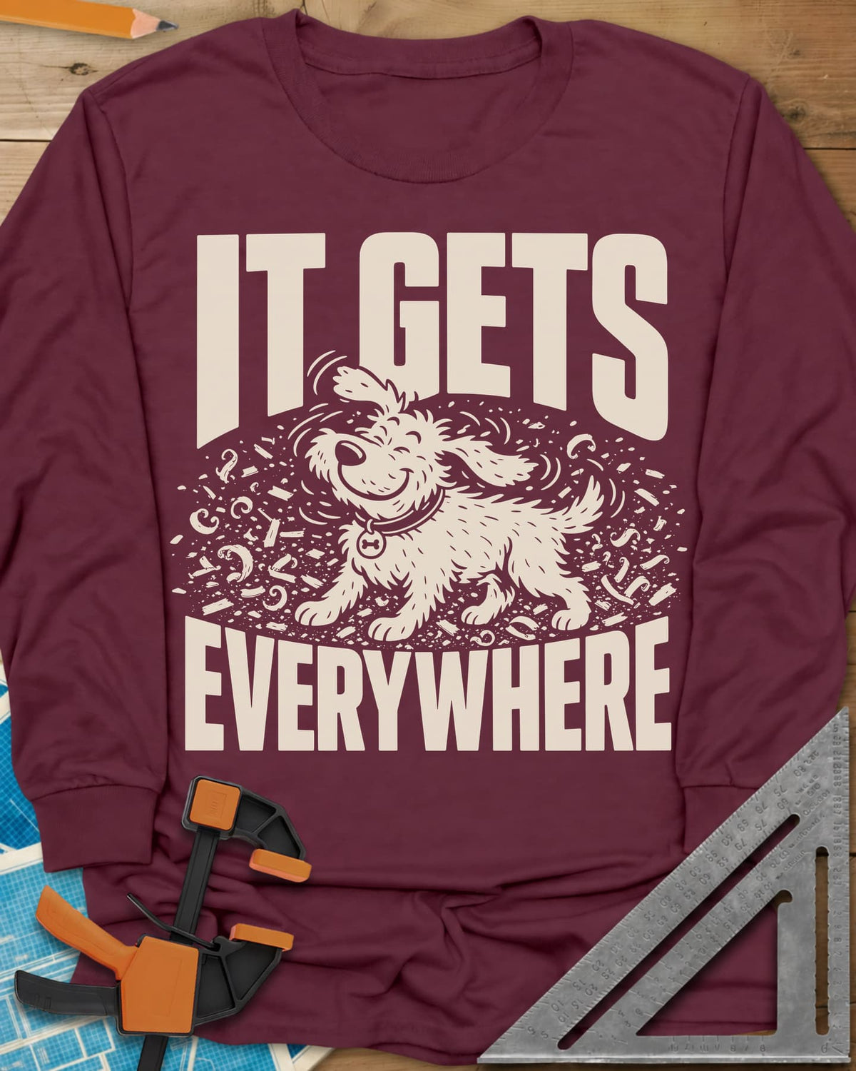 It Gets Everywhere long sleeve shirt in Maroon, a happy shaggy dog shaking in a swirl of wood shavings