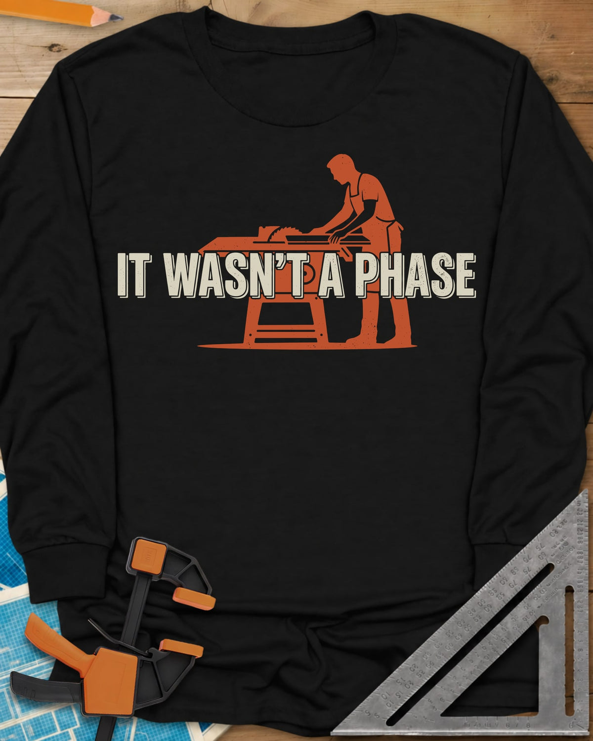 It Was Not A Phase Woodworking long sleeve shirt in Black, a rust-orange silhouette of a woodworker in an apron at a table