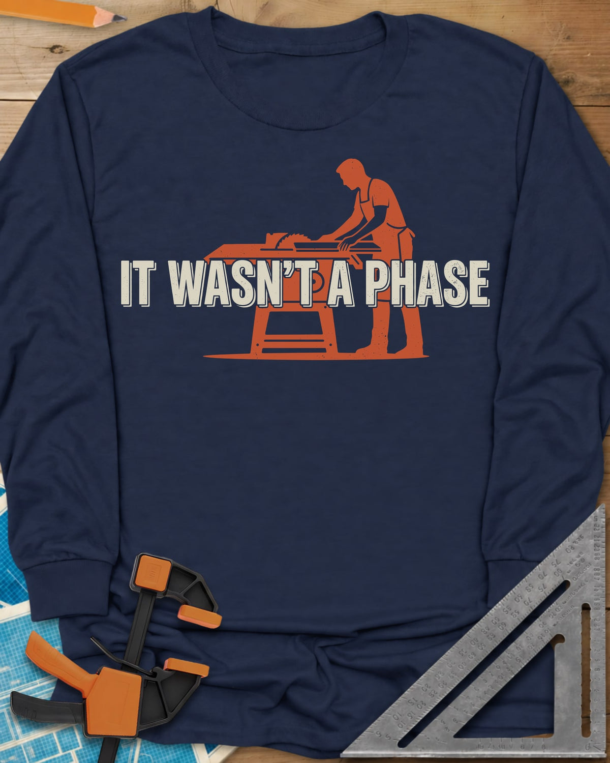 It Was Not A Phase Woodworking long sleeve shirt in Navy, a rust-orange silhouette of a woodworker in an apron at a table saw