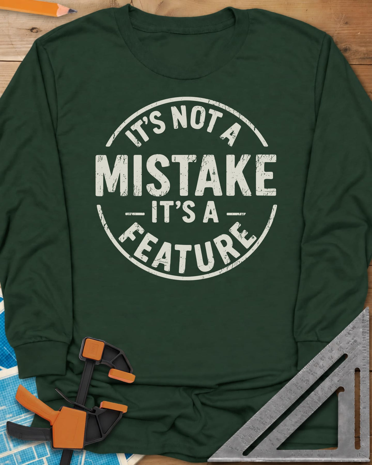 It's Not a Mistake long sleeve shirt in Forest Green, a worn circular stamp with MISTAKE in large letters at the center