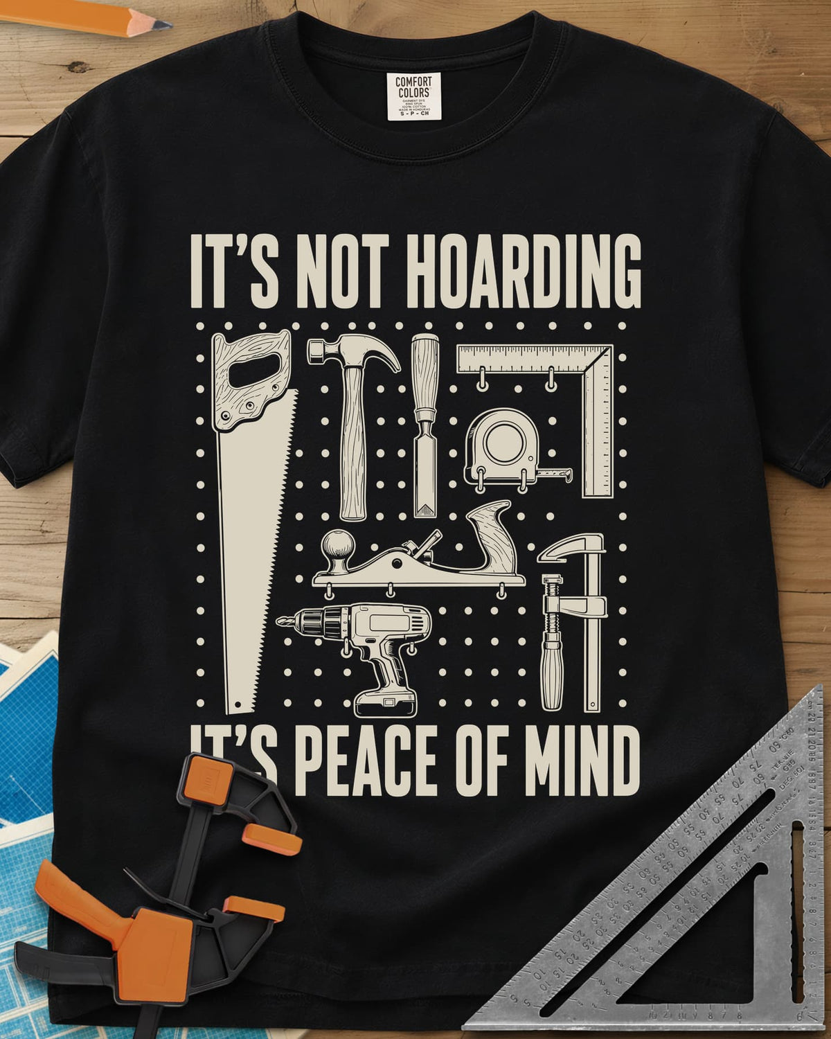 It's Not Hoarding It's Peace Of Mind heavyweight tee in Black, a dotted pegboard grid of hand tools and a cordless drill