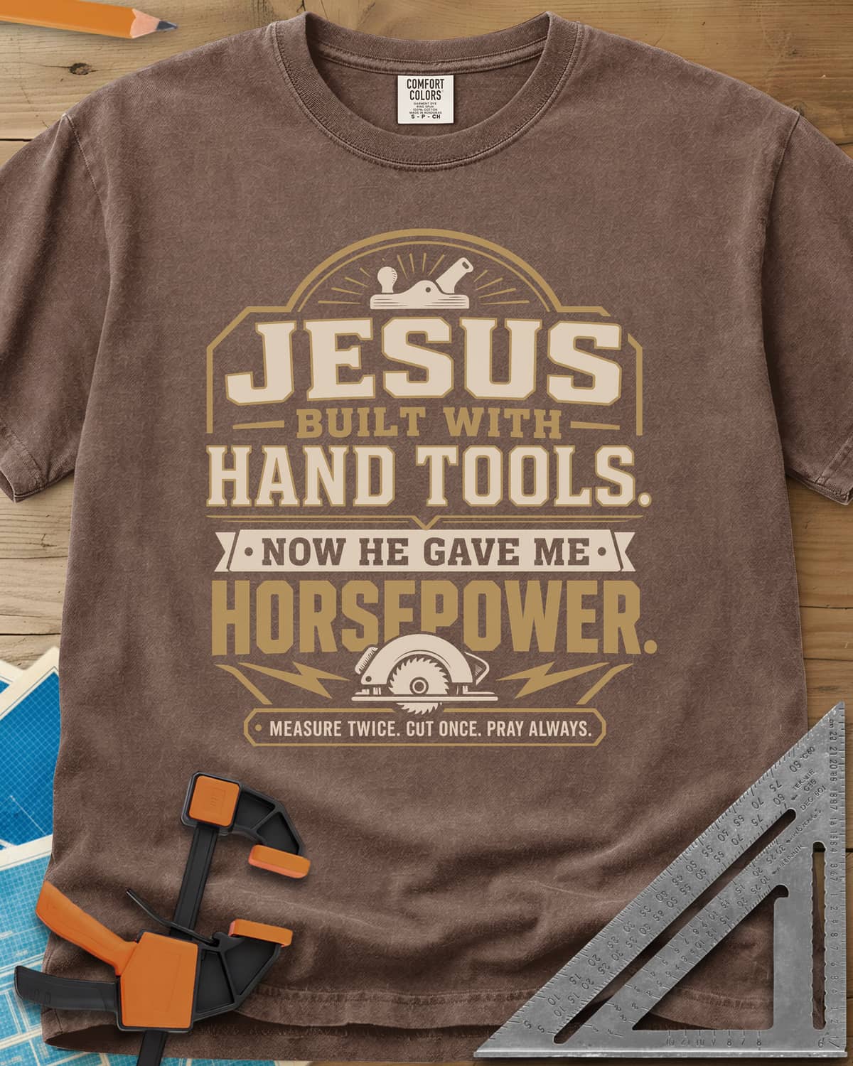 Jesus Built With Hand Tools heavyweight tee in Espresso, a hand plane over bold lettering, a circular saw with bolts below