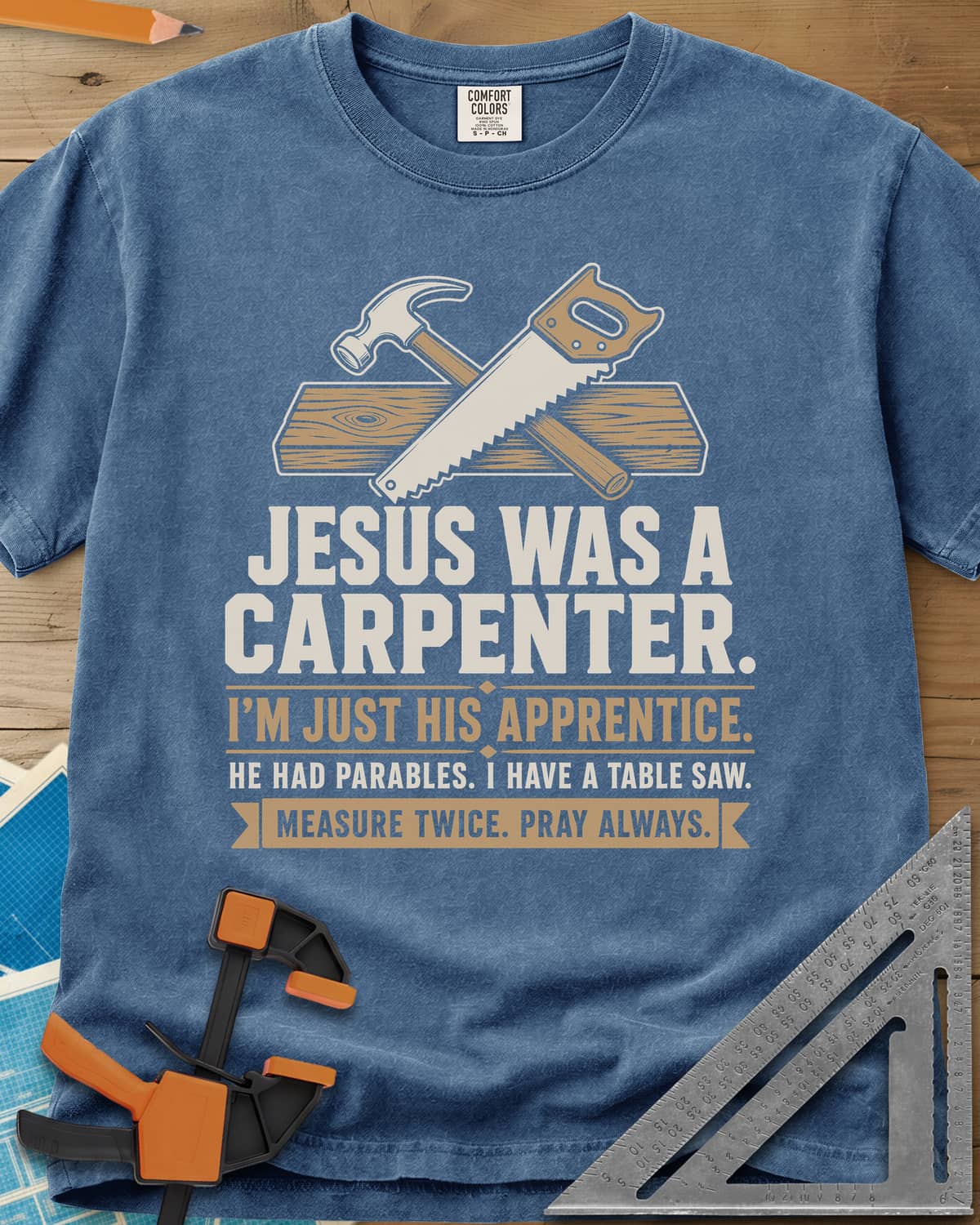 Jesus Was A Carpenter Apprentice heavyweight tee in Blue Jean, crossed hammer and hand saw over a plank, with stacked