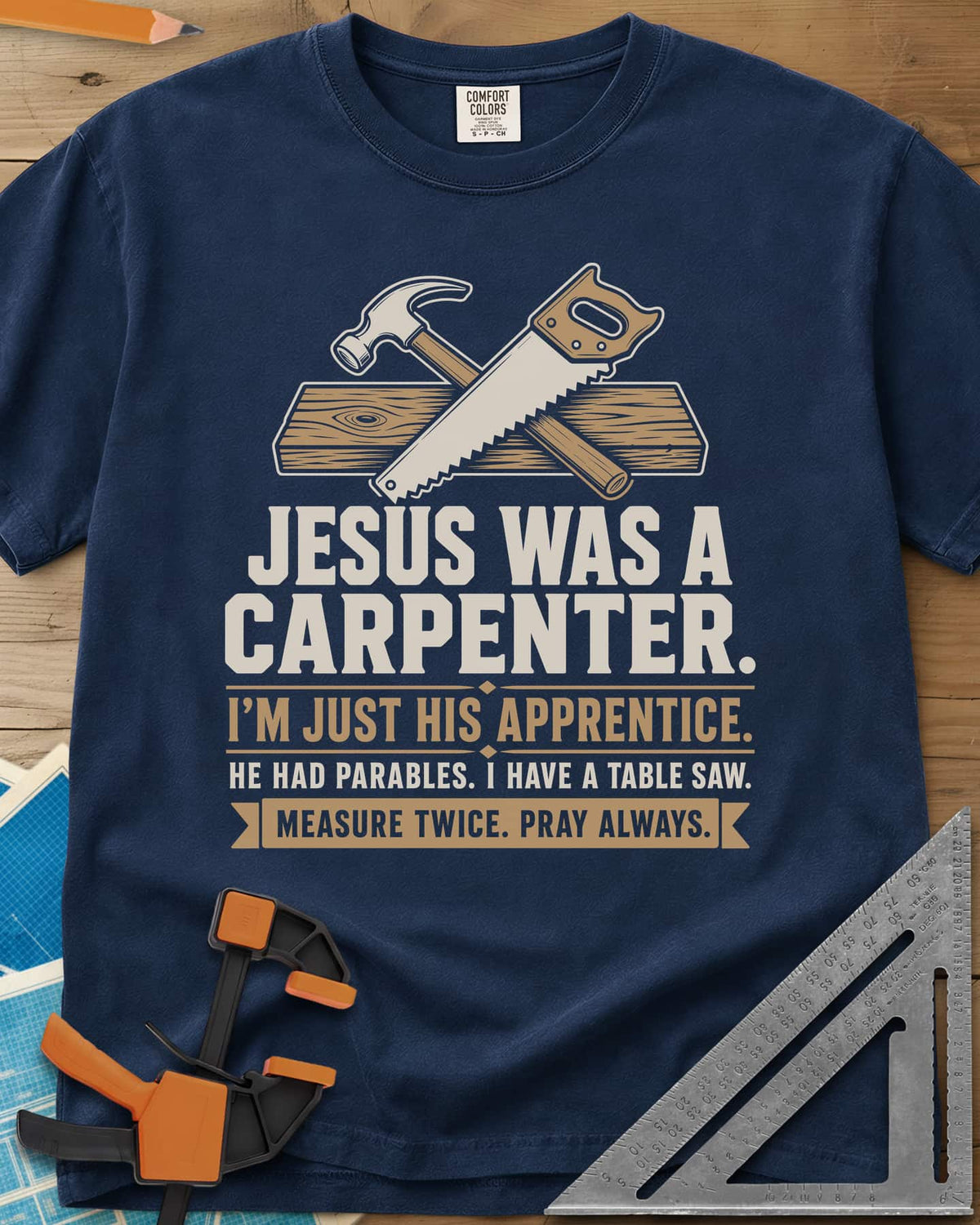 Jesus Was A Carpenter Apprentice heavyweight tee in Navy, crossed hammer and hand saw over a plank, with stacked lettering