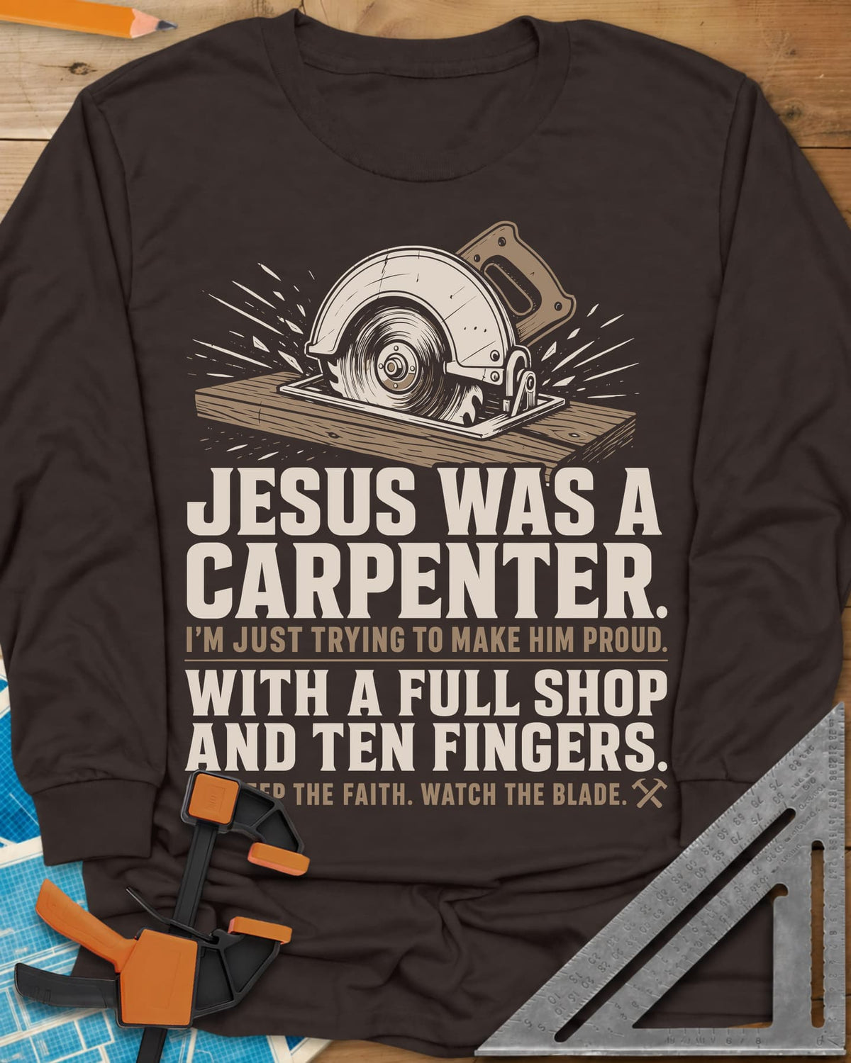 Jesus Was A Carpenter Proud long sleeve shirt in Dark Chocolate, a circular saw cutting a board with sparks flying