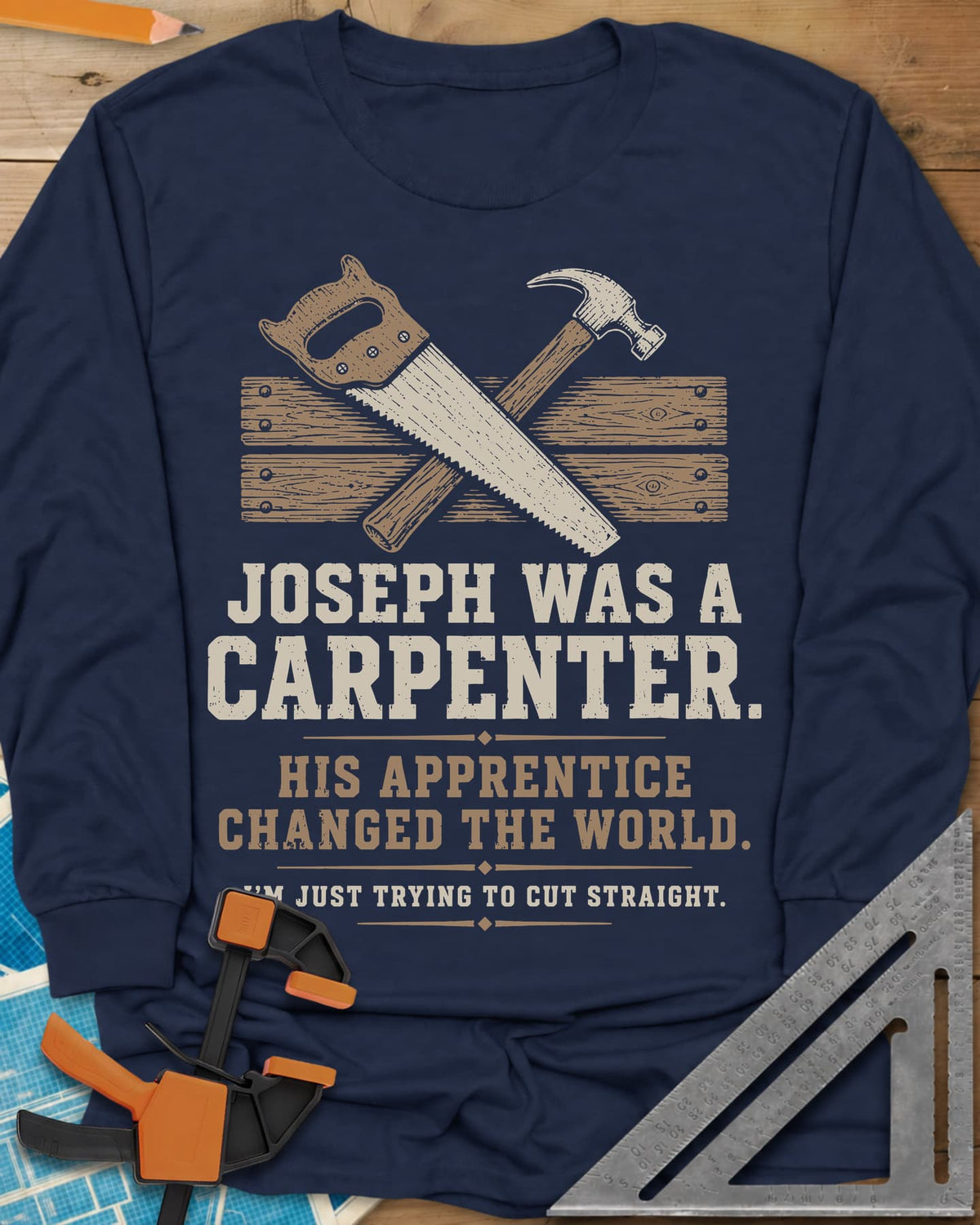 Joseph Was A Carpenter long sleeve shirt in Navy, a crossed hand saw and hammer over two weathered boards