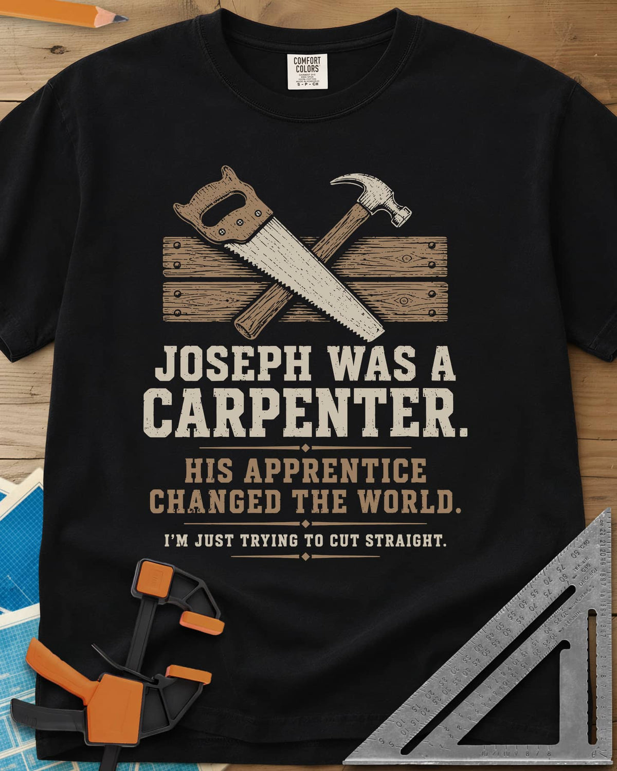 Joseph Was A Carpenter heavyweight tee in Black, a crossed hand saw and hammer over two weathered boards