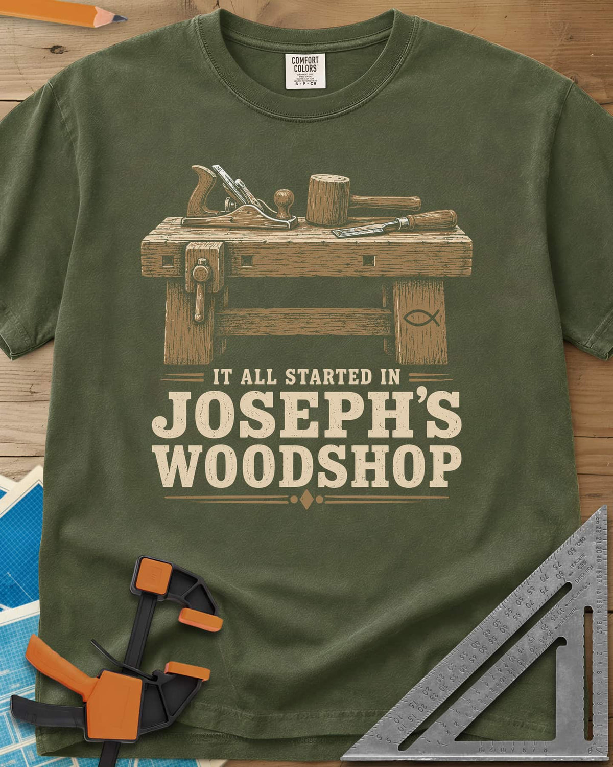 Joseph's Woodshop heavyweight tee in Hemp, a workbench with plane, mallet and chisel and a small fish symbol