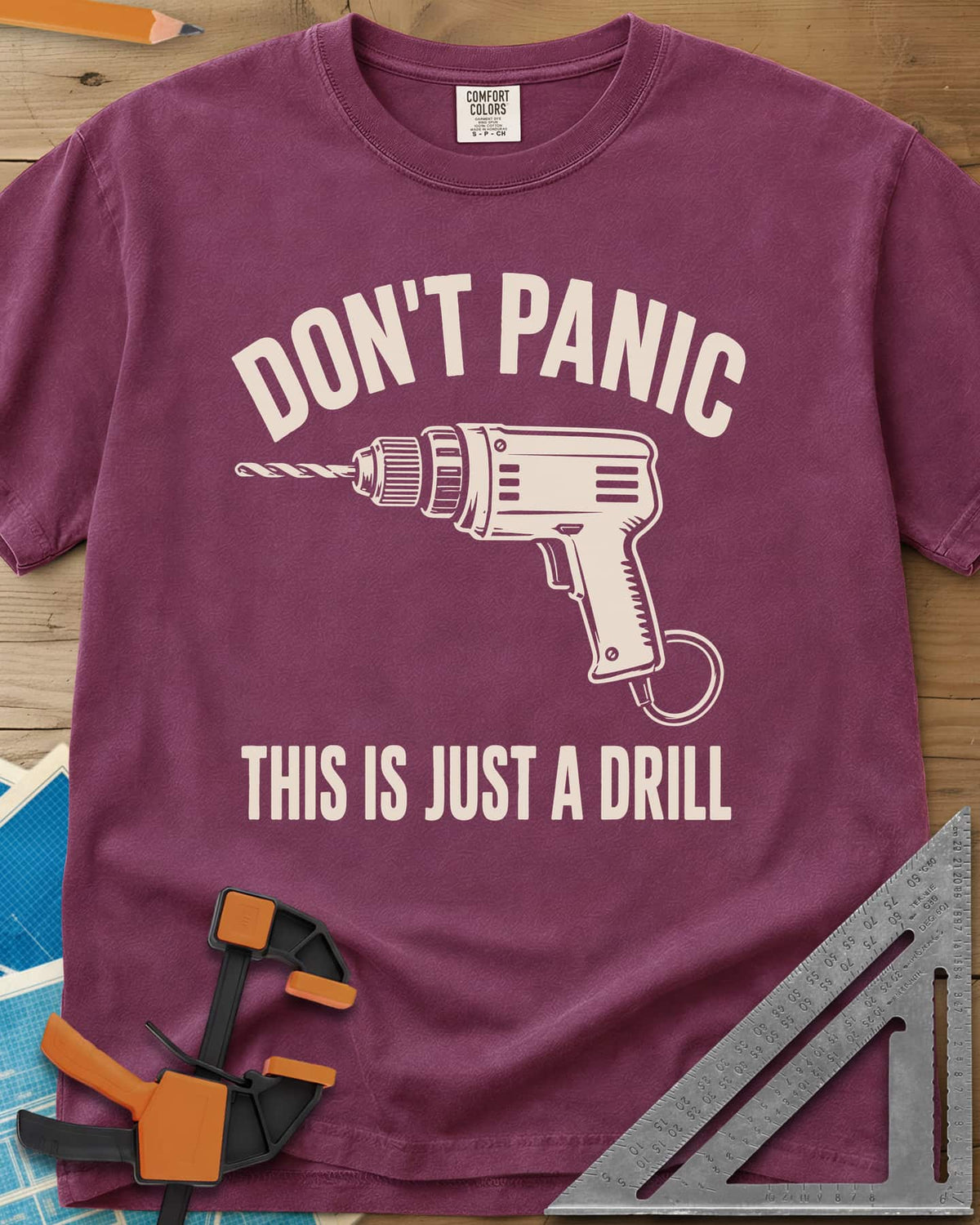 Just A Drill heavyweight tee in Berry, a corded power drill between DON’T PANIC and the punchline