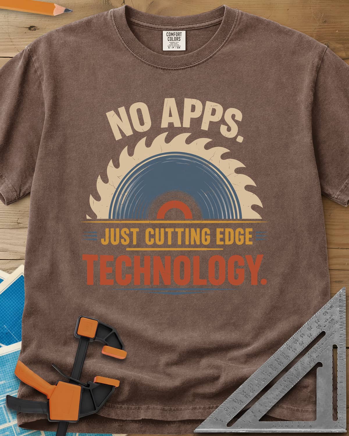 Just Cutting Edge Technology heavyweight tee in Espresso, half a saw blade rising like a sun in cream, blue and rust