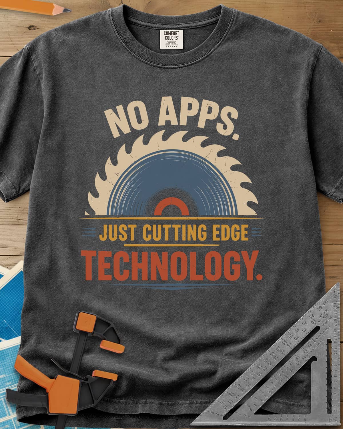 Just Cutting Edge Technology heavyweight tee in Pepper, half a saw blade rising like a sun in cream, blue and rust