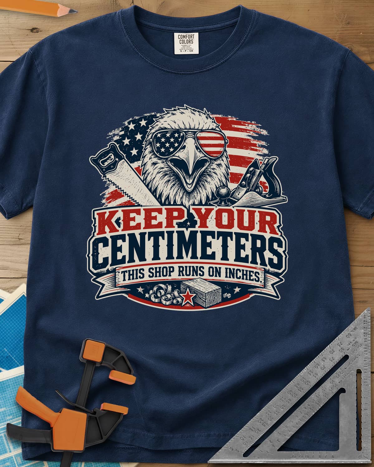 Keep Your Centimeters heavyweight tee in Navy, an eagle in flag sunglasses with a handsaw, plane and banner