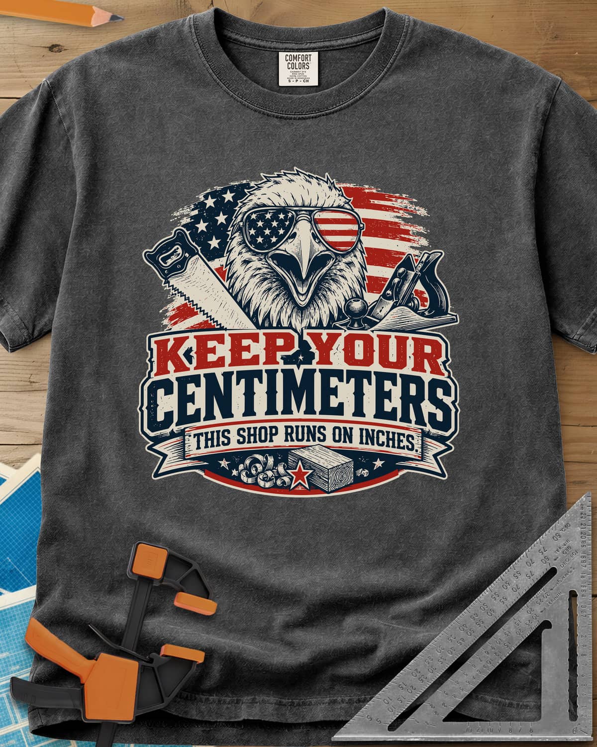 Keep Your Centimeters heavyweight tee in Pepper, an eagle in flag sunglasses with a handsaw, plane and banner