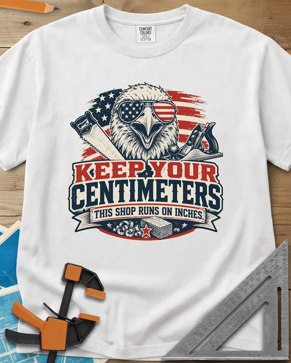 Keep Your Centimeters heavyweight tee in White, an eagle in flag sunglasses with a handsaw, plane and banner