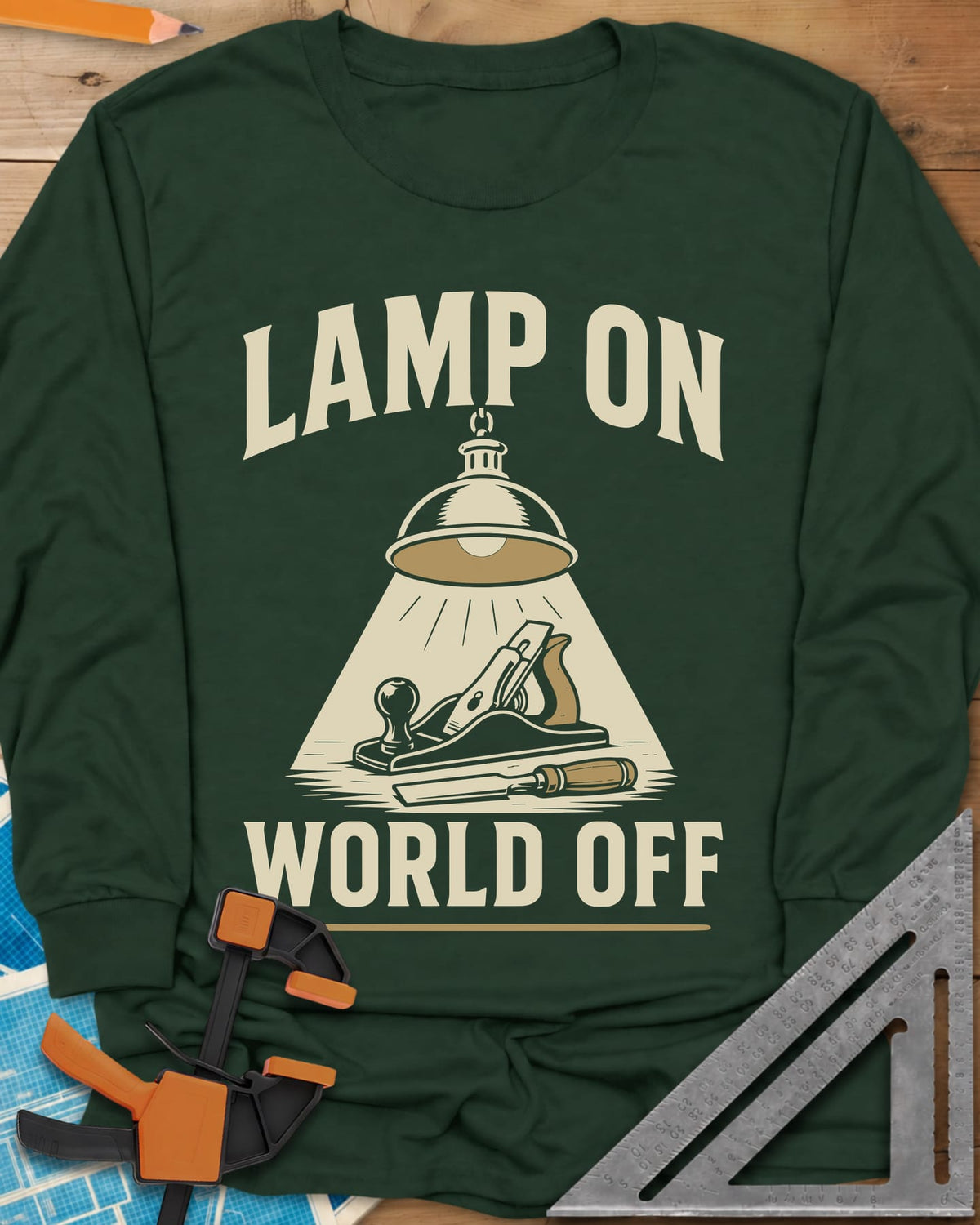 Lamp On World Off long sleeve shirt in Forest Green, a pendant shop lamp lighting a hand plane and chisel