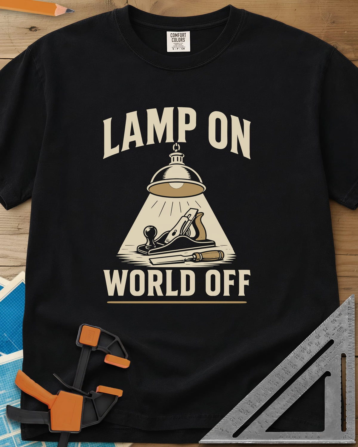 Lamp On World Off heavyweight tee in Black, a pendant shop lamp lighting a hand plane and chisel