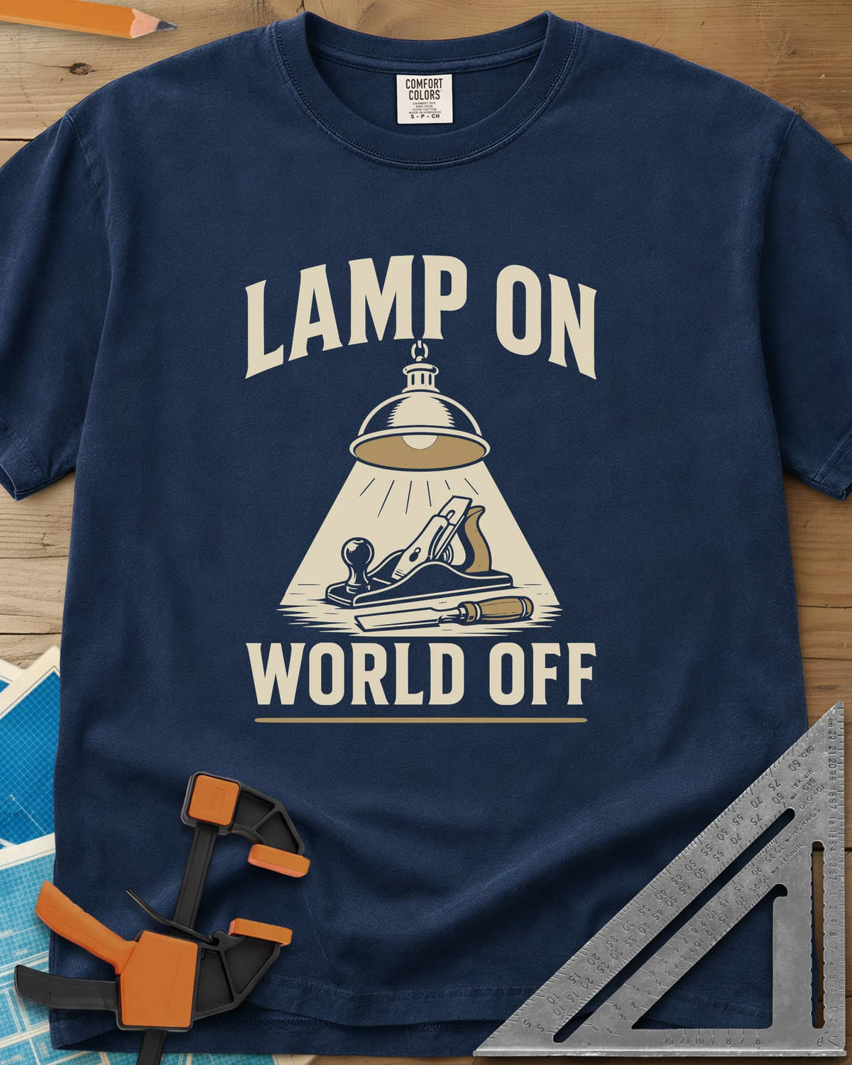 Lamp On World Off heavyweight tee in Navy, a pendant shop lamp lighting a hand plane and chisel
