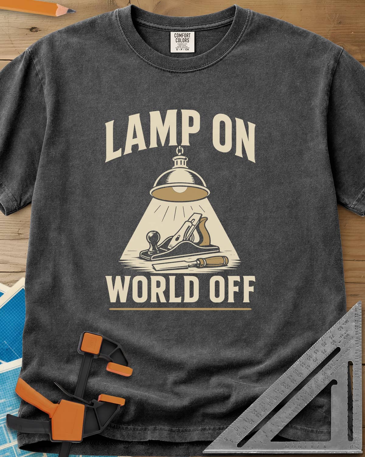 Lamp On World Off heavyweight tee in Pepper, a pendant shop lamp lighting a hand plane and chisel
