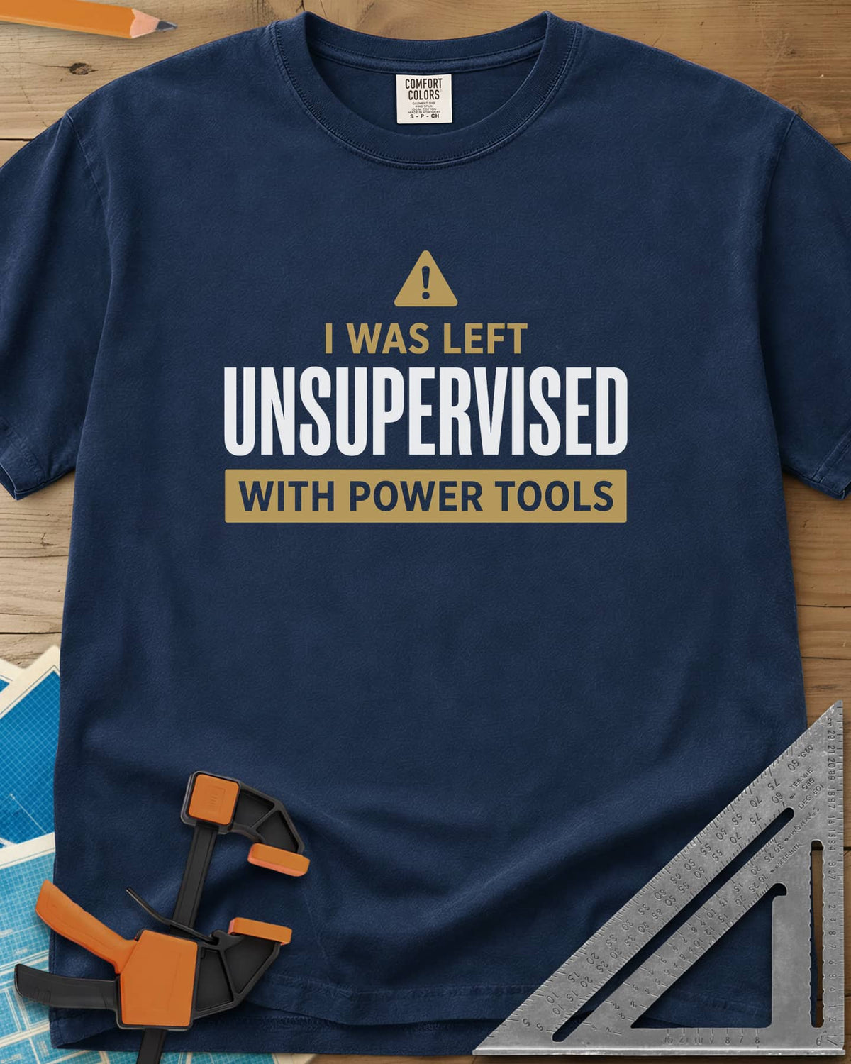 Left Unsupervised With Power Tools heavyweight tee in Navy, a warning triangle above bold lettering in a gold bar