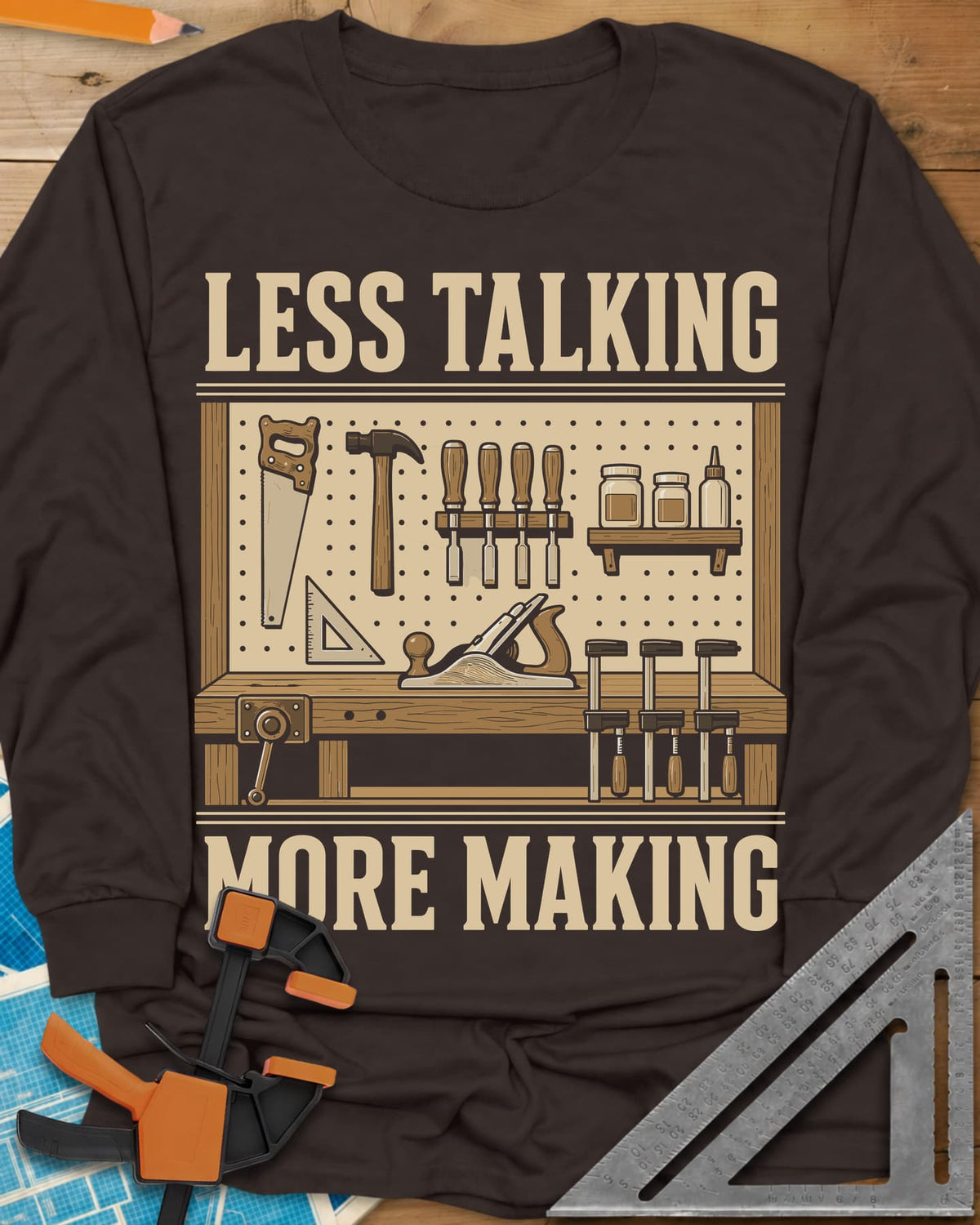 Less Talking More Making long sleeve shirt in Dark Chocolate, a pegboard of hand tools over a workbench with a plane and