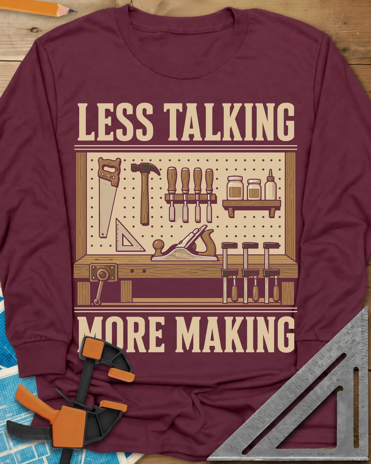 Less Talking More Making long sleeve shirt in Maroon, a pegboard of hand tools over a workbench with a plane and clamps