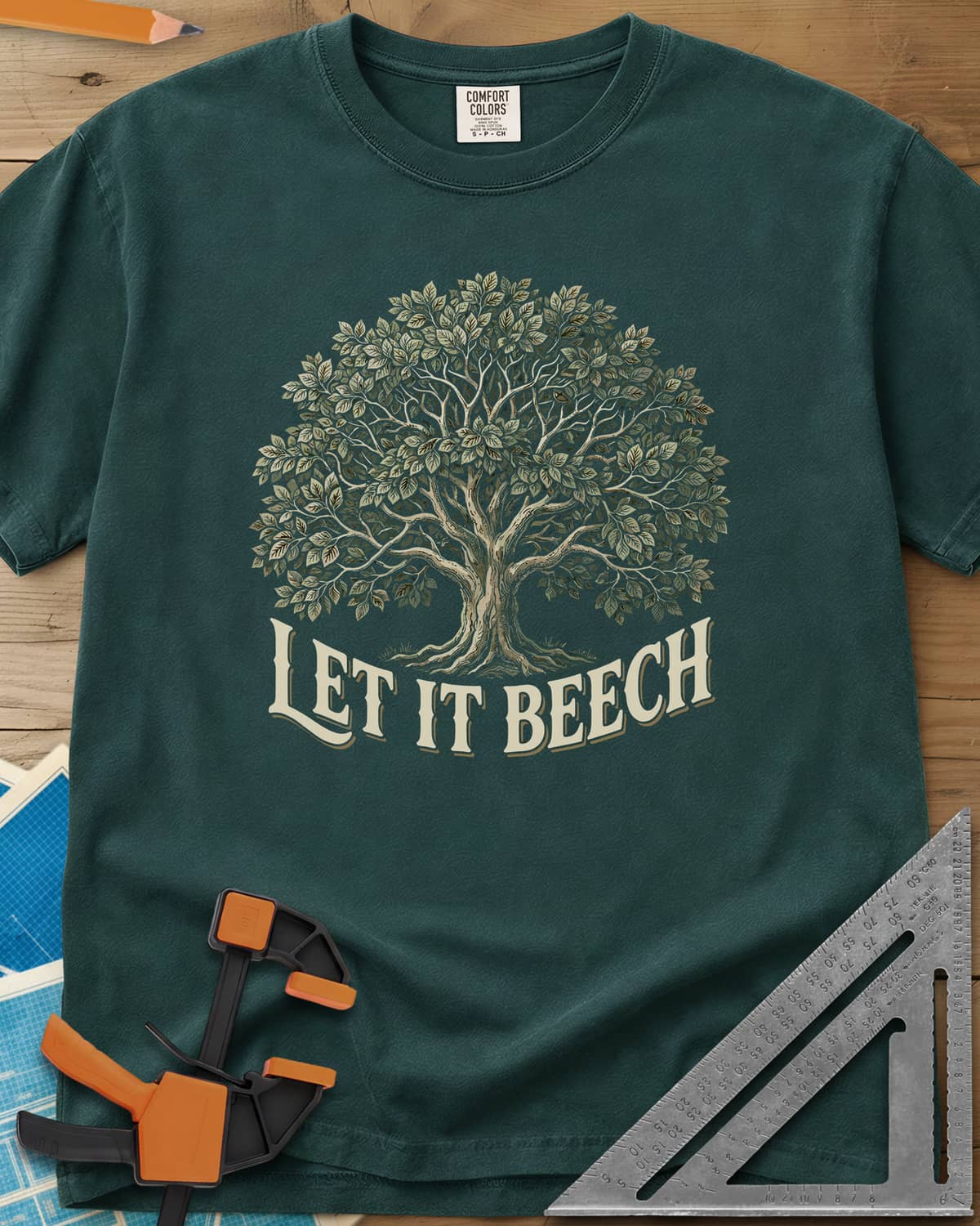 Let It Beech heavyweight tee in Blue Spruce, a detailed beech tree in full leaf above curved cream lettering