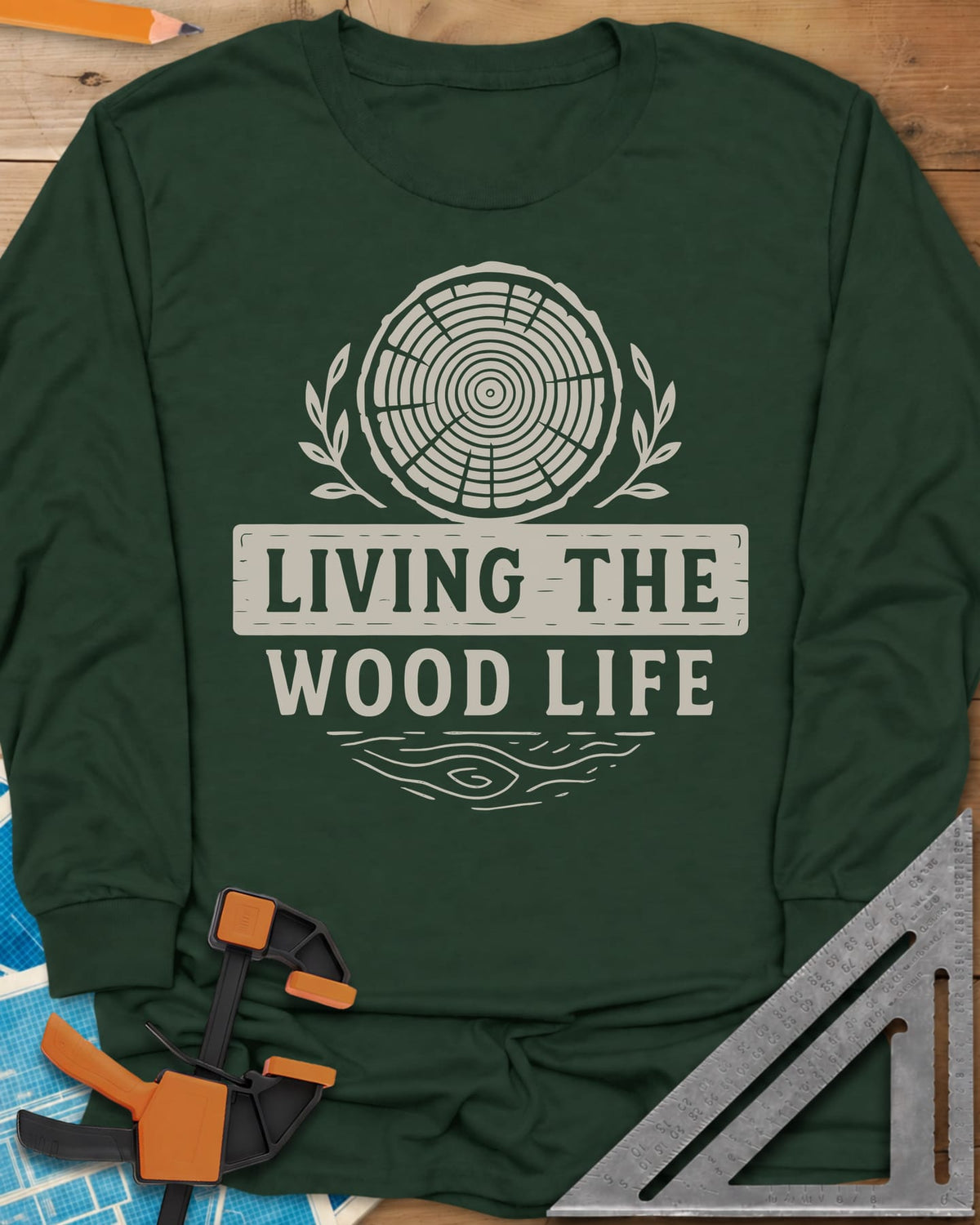 Living The Wood Life long sleeve shirt in Forest Green, a log slice with laurel sprigs and a plank banner