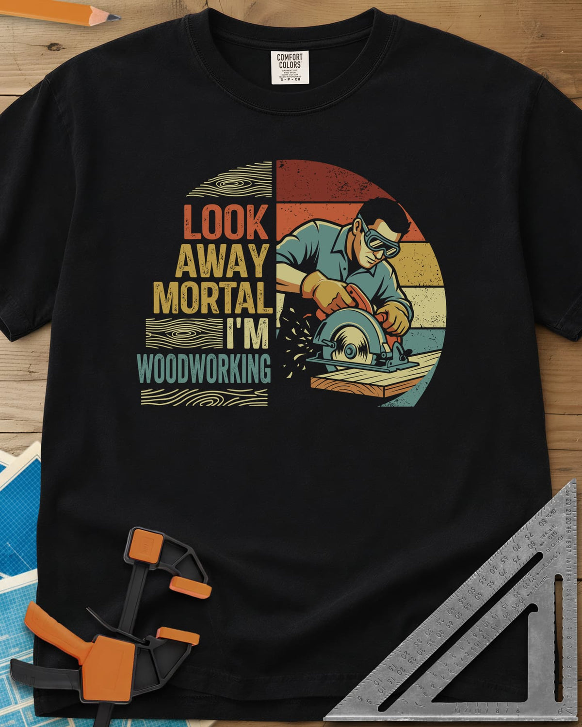 Look Away heavyweight tee in Black, a goggled man cutting a board with a circular saw, retro stripes