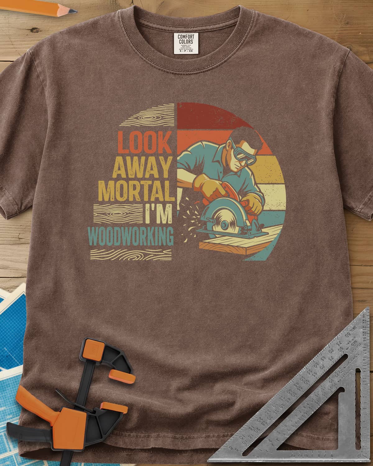 Look Away heavyweight tee in Espresso, a goggled man cutting a board with a circular saw, retro stripes