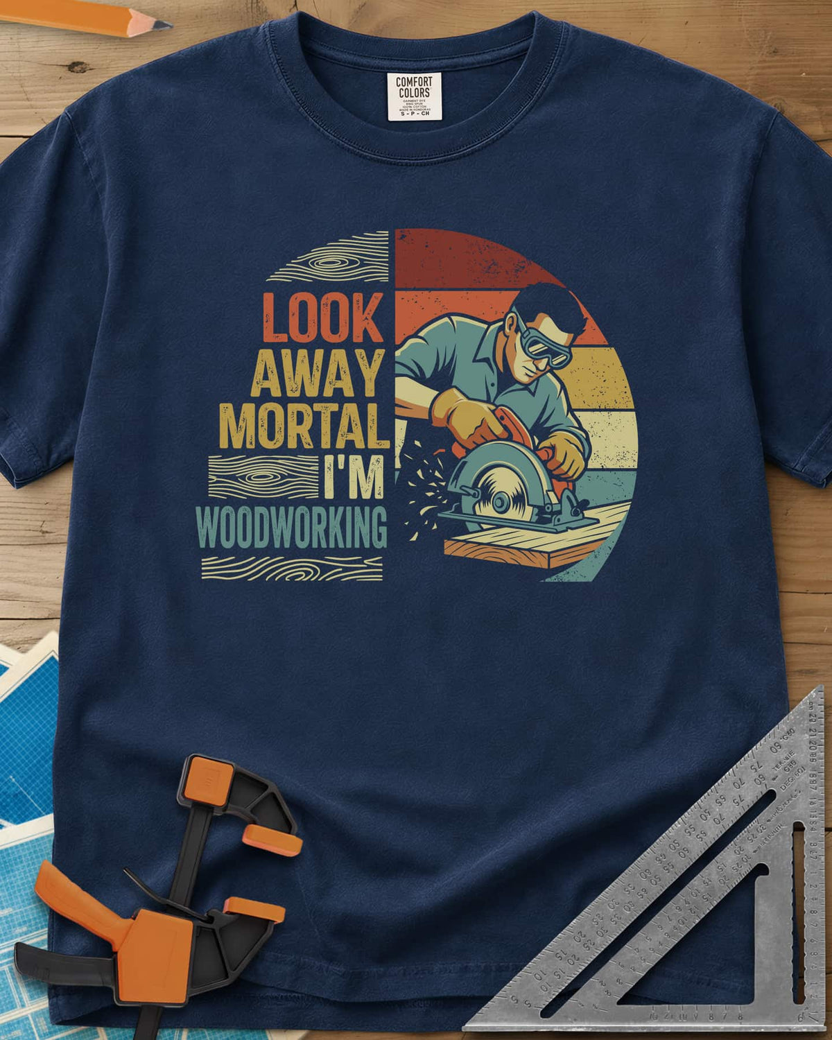 Look Away heavyweight tee in Navy, a goggled man cutting a board with a circular saw, retro stripes