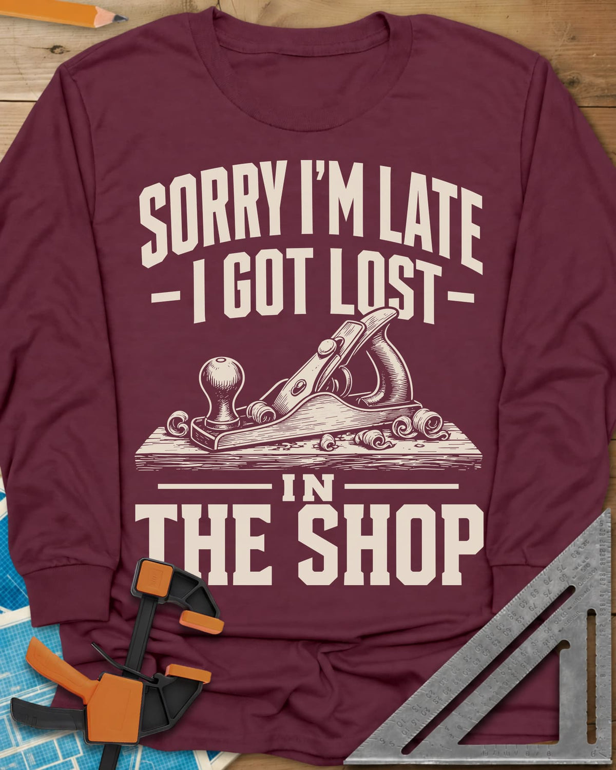 Lost In The Shop long sleeve shirt in Maroon, a bench hand plane on a board among curled shavings