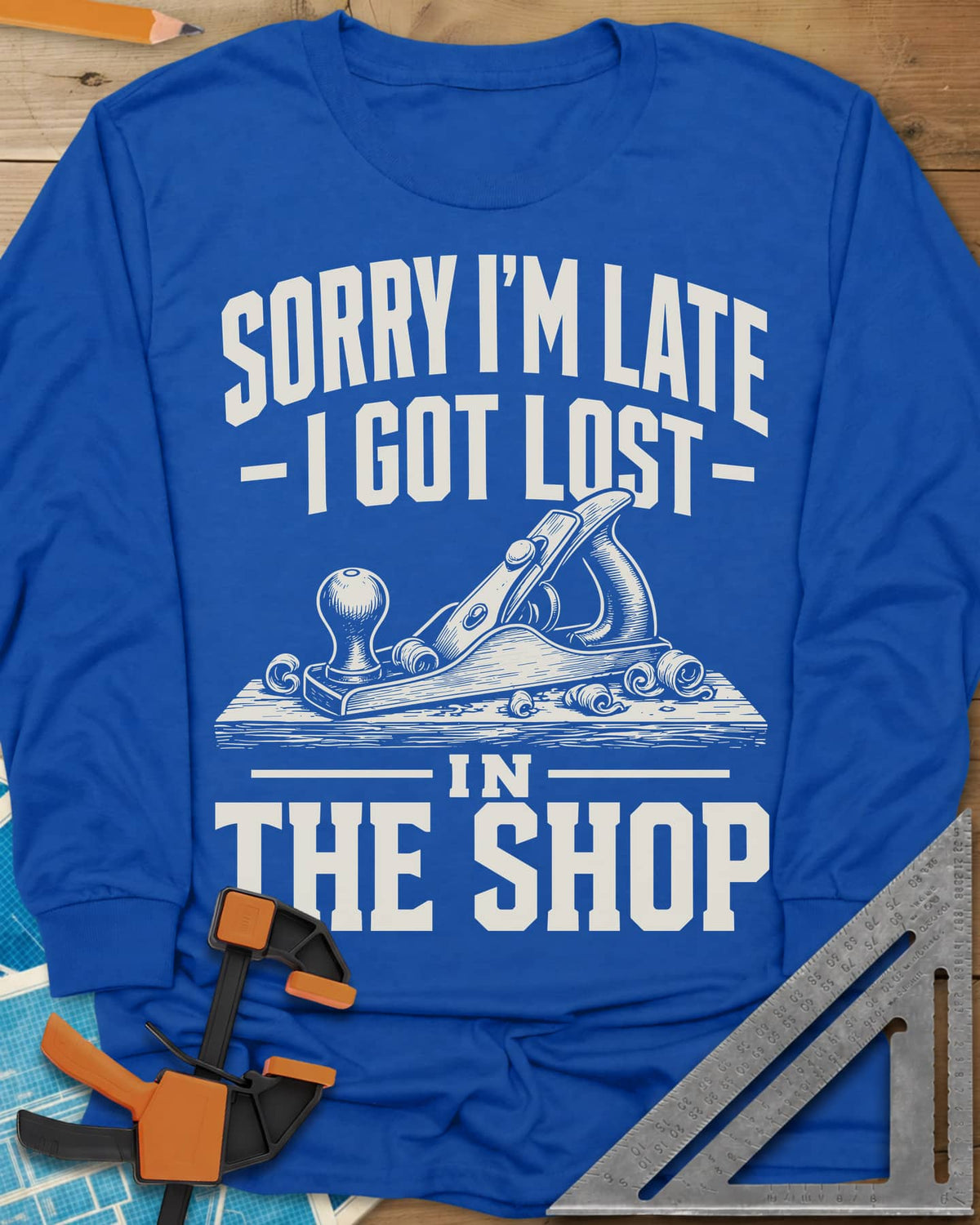 Lost In The Shop long sleeve shirt in Royal, a bench hand plane on a board among curled shavings