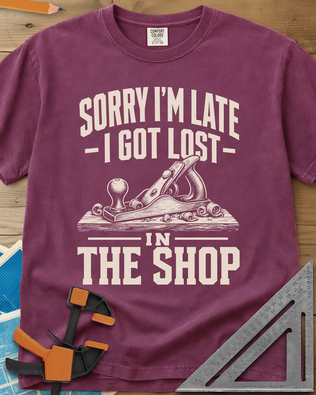 Lost In The Shop heavyweight tee in Berry, a bench hand plane on a board among curled shavings