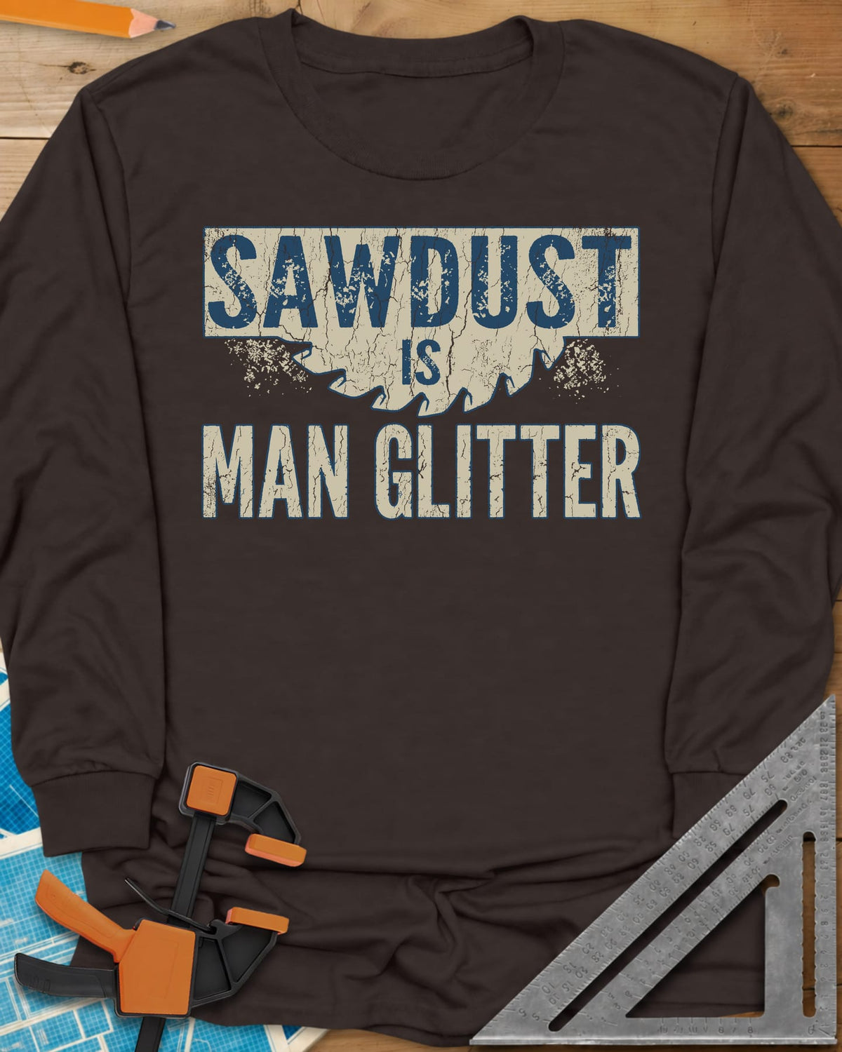Man Glitter long sleeve shirt in Dark Chocolate, distressed lettering over a circular saw blade and sawdust specks