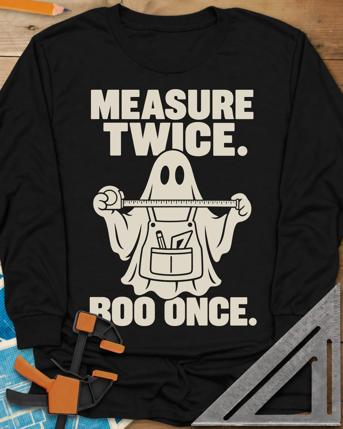 Measure Twice, Boo Once long sleeve shirt in Black, a ghost in a tool apron holding a stretched tape measure