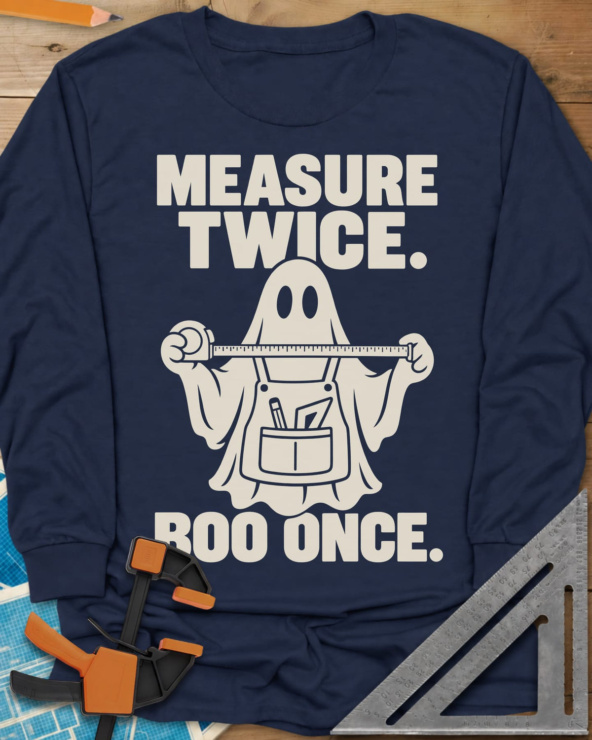 Measure Twice, Boo Once long sleeve shirt in Navy, a ghost in a tool apron holding a stretched tape measure