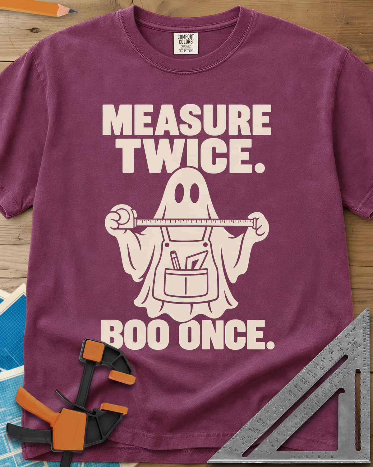 Measure Twice, Boo Once heavyweight tee in Berry, a ghost in a tool apron holding a stretched tape measure